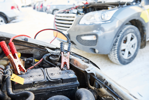winter road assistance. Auto engine starting problem. Car battery discharged. Charging by booster jumper cables
